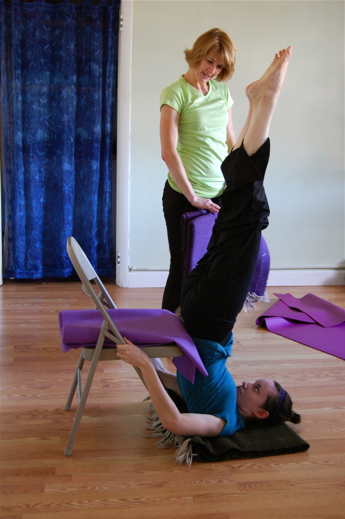 Shoulderstand with the improper use of the Chair Can you tell me what is wrong here?   The blankets that were intended to go under her shoulders to support a nice healthy cervical spine are still in Joni's hands! No worries, moments like this prompted this very useful visual aid to help Clayton Yoga students remember how to set up for each pose safely and get much better results.