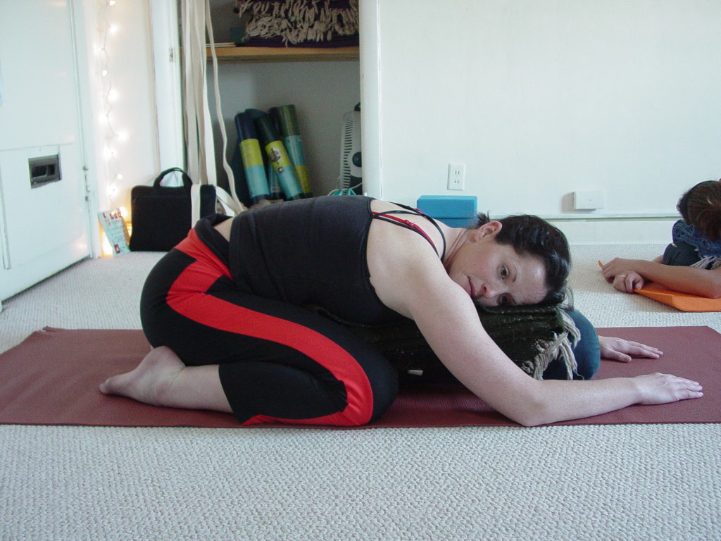 The Supported Child Pose. This is an excellent way to help students who have trouble with forward tilt of their pelvis. In 90% of all cases, when this happens, the pelvis does not tilt due to compression.  Patiently work with your students. Interact with them and ask them to try this posture AND ask them to take their knees out as wide apart as the long edge of the mat. This feels very restorative and great for those who have challenging seated postures!