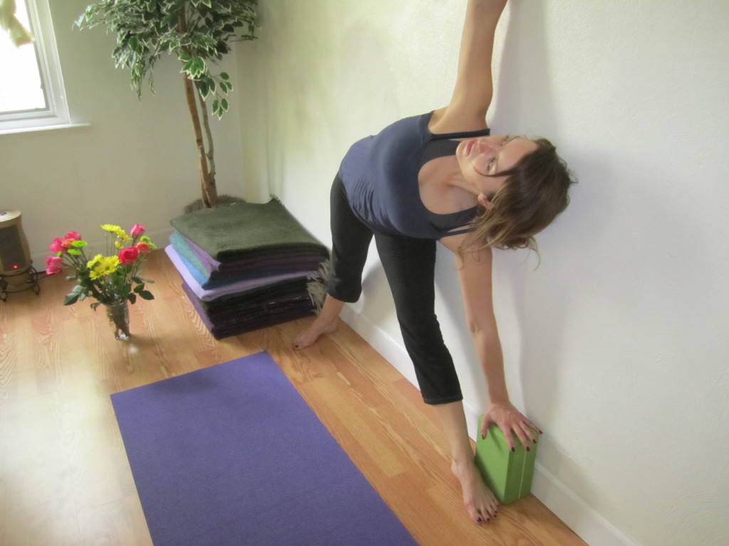 Amy really worked with her principles of alignment here.  Because of the correct positioning in the front leg, she is able to truly access the opening in the front hip and feel the back body neutral and pressed against the wall.  Remember, bend the front leg first, step on the gas (front big toe), then pivot from the hip and elongate the front leg.  The use of the block is also supportive and great!